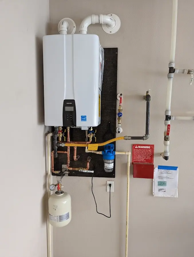 Professional plumber installing copper piping in a Beekmantown home